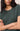 Person wearing a green t-shirt with arms crossed against a neutral background