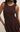 Brown sleeveless dress worn by a model on a plain background