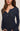 Woman wearing a navy ribbed long-sleeve top against a neutral background