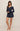 Woman wearing navy blue pajama set on a beige background
