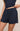 Navy blue shorts worn by a person on a beige background