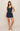 Woman wearing a navy blue tank top and shorts set on a beige background