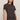 Woman wearing a dark brown t-shirt and pants on a beige background