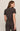 Woman wearing a brown t-shirt and leggings against a beige background