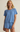 Woman wearing a blue textured top and shorts set on a beige background