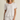 Woman wearing a white ribbed t-shirt and shorts set on a beige background