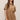 Woman wearing a brown suede dress against a plain background