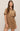 Woman wearing a brown suede dress against a plain background