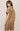 Woman wearing a brown suede dress against a plain background