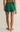 Green shorts worn by a person on a beige background