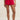 Red shorts worn by a person on a plain background