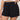 Black polka dot shorts worn by a person on a plain background