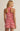 Woman wearing a red and white striped romper against a beige background