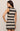 Woman wearing a black and beige striped dress against a plain background
