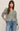 Woman wearing a striped sweater and jeans against a plain background