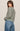 Woman wearing a striped sweater and jeans against a plain background