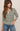 Woman wearing a striped sweater and jeans against a neutral background