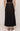 Person wearing a black skirt on a plain background