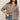 Woman wearing a brown checkered shirt and blue jeans on a beige background