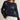 Woman wearing a navy sweater with white shell patterns on a beige background