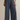 Person wearing blue wide-leg pants on a beige background