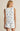 Woman wearing a sleeveless top and shorts with blue floral patterns on a beige background