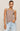 Woman wearing a brown tank top and light blue jeans against a beige background