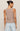 Woman wearing a brown sleeveless top and light blue jeans on a beige background