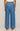 Blue denim wide-leg pants worn by a person on a beige background