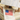 Person wearing a sleeveless top with an American flag design, holding a map above their head.