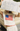 Person wearing a sleeveless top with an American flag design, holding a map above their head.
