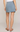 Light blue denim skirt worn by a person on a plain background