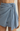 Light blue denim skirt worn by a person on a beige background