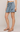 Person wearing a light blue tied skirt on a plain background
