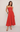 Woman wearing a strapless red dress on a plain background