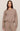 Woman wearing a brown sweater and pants on a beige background