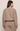 Person wearing a brown sweater and pants set on a beige background