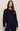 Woman wearing a navy blue sweater and pants on a beige background