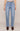 Light blue jeans worn by a person on a beige background