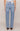 Light blue jeans worn by a person on a beige background