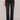 Person wearing black jeans and black boots on a plain background