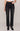 Person wearing black jeans and black boots on a plain background